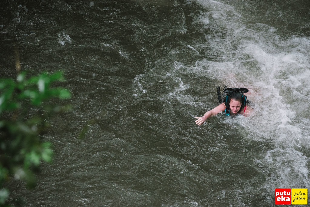 Wisatawan mancanegara sedang berenang ketepian setelah meluncur dari puncak air terjun