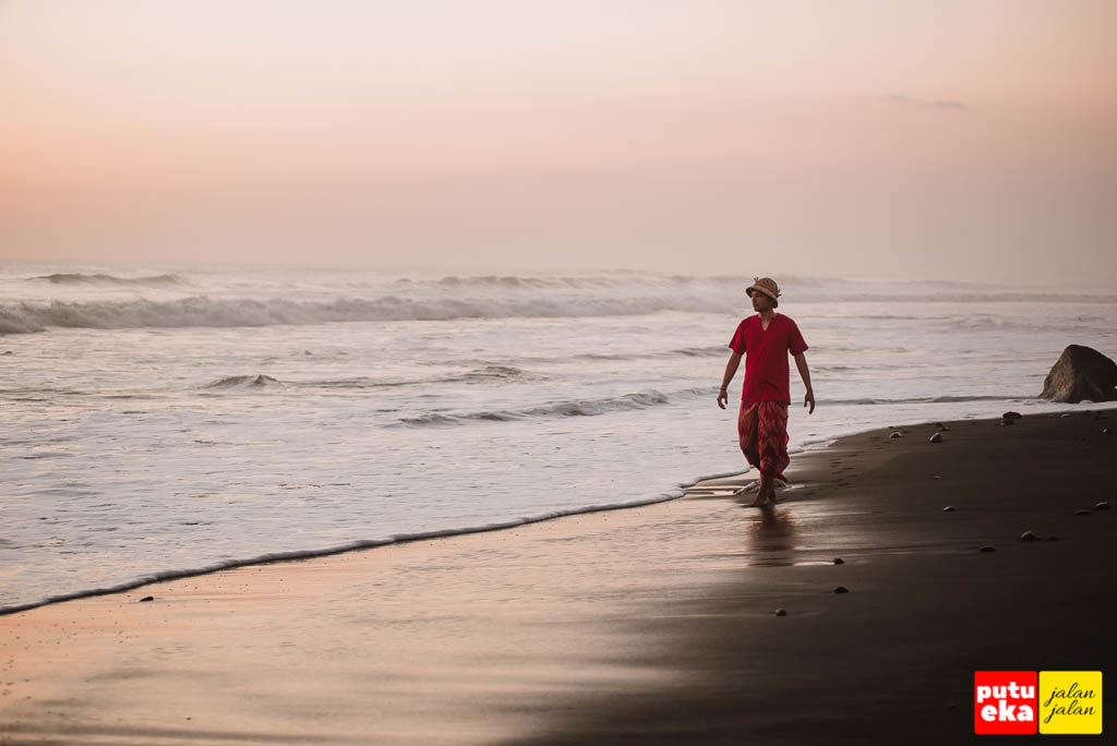 Berjalan menyusuri pantai ketika matahari terbenam tiba