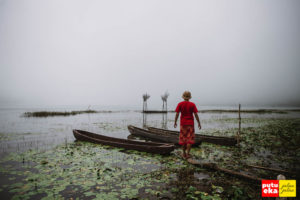 Berdiri di tepian Danau Tamblingan dengan perahu tradisional ketika kabut sedang turun menyelimuti
