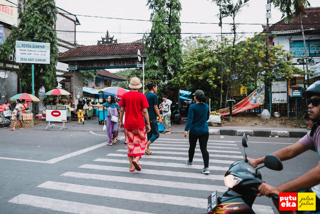 Putu Eka Jalan Jalan sedang menyebrang jalan menuju Pasar Senggol Gianyar